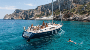 adventure travel photograph of a small group of adult travellers enjoying a private sailing boat along the coast of Crete, Greece, turquoise Cretan Sea
