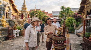 photograph of adult international travellers respectfully experiencing Thai culture in Pattaya, visiting an ornate traditional Thai temple courtyard, intricate golden architecture, Buddhist decorative details, tropical plants