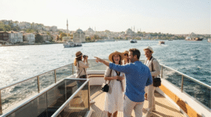 lifestyle travel photograph taken from a Bosphorus cruise in Istanbul, Turkey, adult travellers standing on the open deck of a modern sightseeing boat