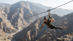 professional adventure photograph of Jais Flight on Jebel Jais, Ras Al Khaimah, UAE, real adult traveller wearing professional safety