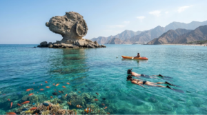 professional coastal travel photograph of Snoopy Island near Al Aqah Beach, Fujairah, UAE, distinctive rocky island naturally surrounded by clear blue Gulf of Oman water