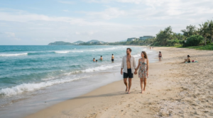 beach travel photograph of Da Nang coastline, Vietnam, wide natural sandy beach with turquoise sea and tropical greenery
