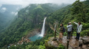 photograph of Nohkalikai Falls near Cherrapunji, Meghalaya, showing a tall waterfall cascading dramatically from a lush green cliff into a natural blue-green pool