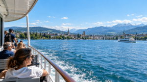 photograph taken aboard a passenger boat cruising across Lake Zurich, Switzerland, camera positioned naturally from the outdoor deck,