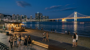 night travel photograph of Busan, South Korea, lively waterfront district with illuminated buildings, restaurants,