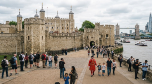 premium historical travel photograph of the Tower of London, impressive medieval stone fortress beside the River Thames, historic towers and walls,