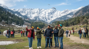 travel photograph of Solang Valley near Manali, Himachal Pradesh, showing a dramatic mountain valley surrounded by snow-covered Himalayan peaks and green alpine slopes.
